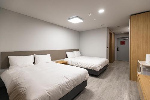 a hotel room with two beds and a bathroom at Hotel Modak Namdaemun in Seoul