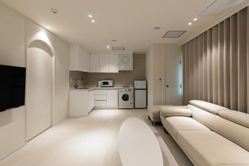 a living room with a couch and a kitchen at Hotel Modak Namdaemun in Seoul