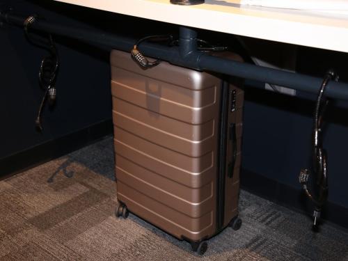 a suitcase sitting under a desk under a table at First Cabin International Hawaii in Honolulu