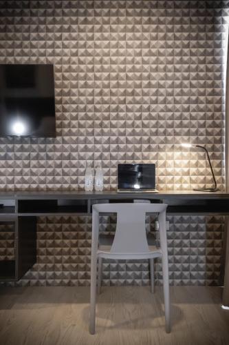a desk with a white chair and a laptop on it at Altitude Loft Hotel in Maracaibo