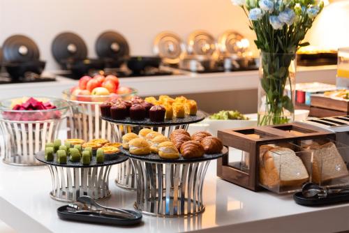 a buffet with three tiers of pastries and bread at 深圳宝安国际会展中心桔子水晶酒店 in Shenzhen