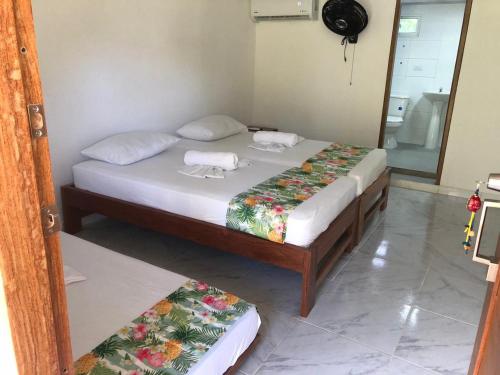 two twin beds in a room with a mirror at Hotel Nuquimar in Nuquí
