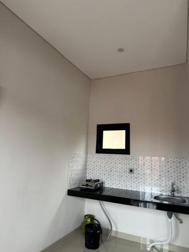 a bathroom with a sink and a mirror on the wall at Kubu Gandi Homestay in Denpasar