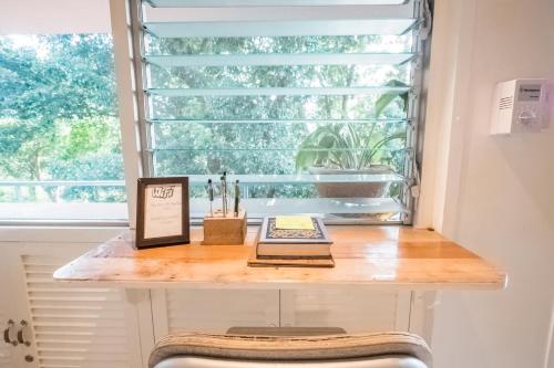 a table in front of a window with books on it at OCEAN Nest with Self-Service Breakfast - AC, Monkeys, Pet-friendly with a Fee in Subic Bay Intl