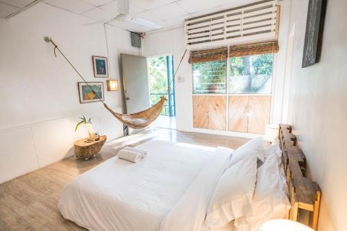 a bedroom with a bed and a hammock in it at OCEAN Nest with Self-Service Breakfast - AC, Monkeys, Pet-friendly with a Fee in Subic Bay Intl
