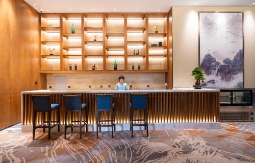 a man standing behind a bar in a hotel lobby at Shangrao International Hotel in Shangrao