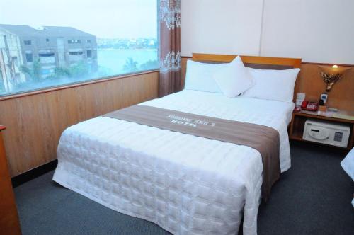 a bedroom with a large bed with a large window at Phuong Anh 3 Hotel in Hai Phong