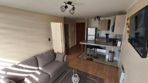 a living room with a couch and a kitchen at Departamento centro Temuco in Temuco