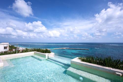 a swimming pool with a view of the ocean at DM504 Apartment with Spectacular Views in Puerto Morelos