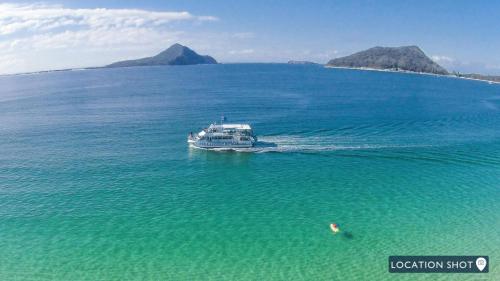 a boat in the middle of a large body of water at Hamptons By The Bay in Nelson Bay