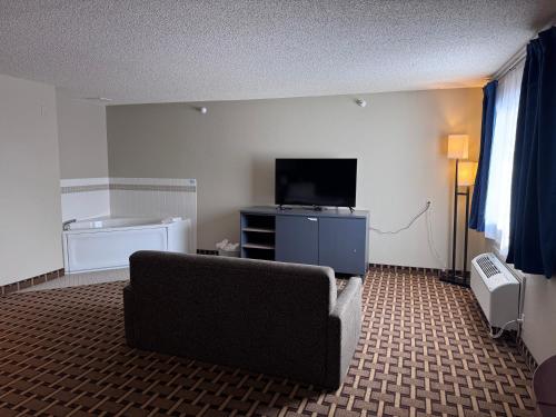 a living room with a couch and a flat screen tv at Crossroads Hotel in McGregor