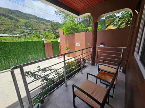 a balcony with two chairs and a table and a view at Agape Suites-Room 1- Ground Floor in Soufrière