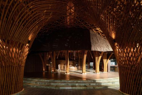 a building with a wooden structure with bamboo poles at Garrya Mù Cang Chải in Mù Cang Chải