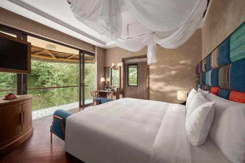 a bedroom with a large white bed and a large window at Garrya Mù Cang Chải in Mù Cang Chải
