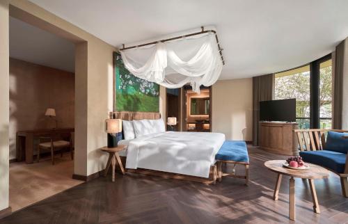 a bedroom with a white bed and a blue couch at Garrya Mù Cang Chải in Mù Cang Chải