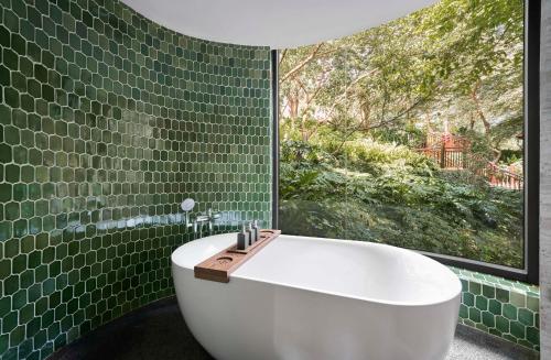 a bath tub in a bathroom with a window at Garrya Mù Cang Chải in Mù Cang Chải