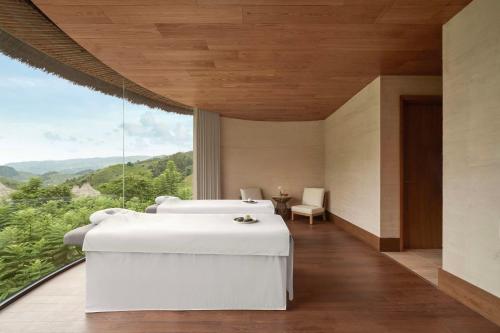 a bedroom with two beds and a large window at Garrya Mù Cang Chải in Mù Cang Chải