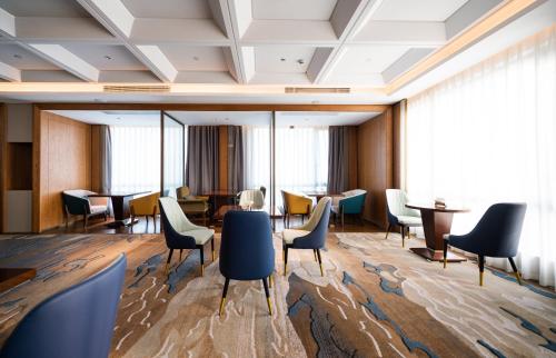 a meeting room with chairs and tables and windows at Shangrao International Hotel in Shangrao