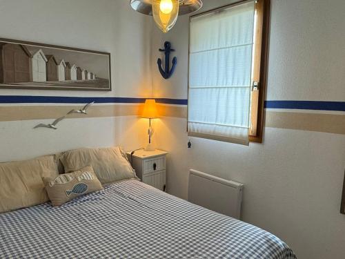 une chambre avec un lit, une lampe et une fenêtre dans l'établissement Appartement 2 pièces près de la plage avec parking à Cabourg - FR-1-487-381, à Cabourg