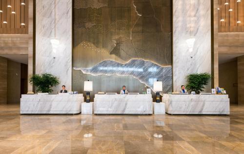 a group of people sitting at tables in a lobby at Shangrao International Hotel in Shangrao
