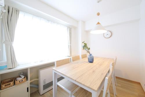 a dining room with a wooden table and a window at ノーザンヒルズ南6条 in Sapporo