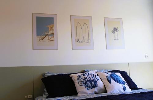 a bedroom with four pictures on the wall and a bed at Apto de duas suítes com vista mar - 100 metros da praia em Canasvieiras in Florianópolis