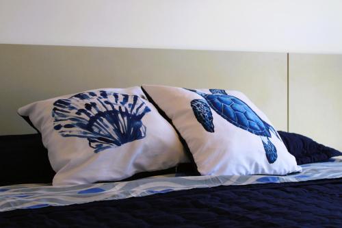 a bed with two pillows on top of it at Apto de duas suítes com vista mar - 100 metros da praia em Canasvieiras in Florianópolis