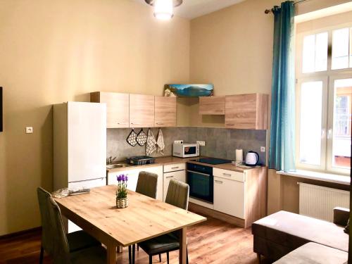 a small kitchen with a wooden table and a dining room at Oasis Valley in Karlovy Vary