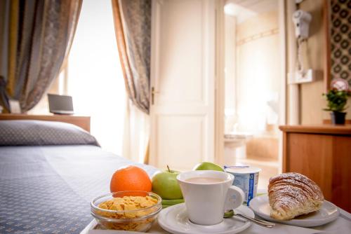 a tray of breakfast foods and coffee on a bed at Hotel Emmaus in Rome