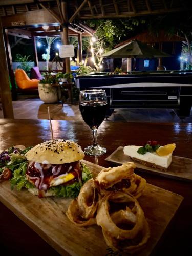 a table with a sandwich and a glass of wine at Ombak Resort at Ekas , a luxury surf and kite destination, Close to Inside Ekas beach in Ekas