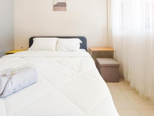a white bed in a room with a window at The TAMU HOUSE Syariah Solo RedPartner in Bonorejo