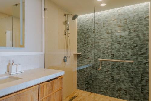 a bathroom with a glass shower with a sink at Condos Privados en Huatulco in Tangolunda
