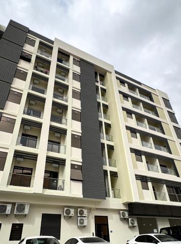 a building with cars parked in front of it at Modern Apartment in Boshar, Muscat in Muscat