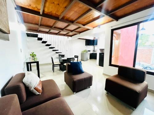 a living room with a couch and chairs and a table at Departamento con terraza en el Centro in Oaxaca City