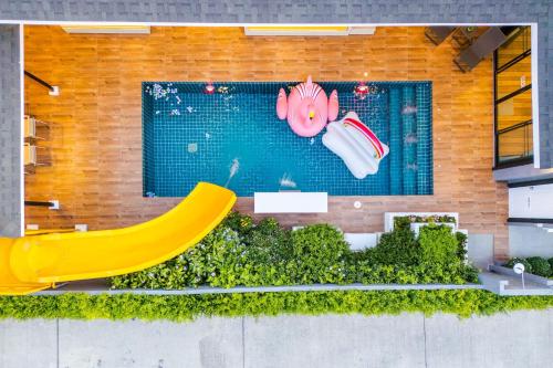 a swimming pool with a slide and a pink pig toy at Hua Hin Pool Villa and Pool table with 3 bedrooms, 3 bathrooms near Cha-Am beach in Nikhom Sang Ton Eng Khuan Phet