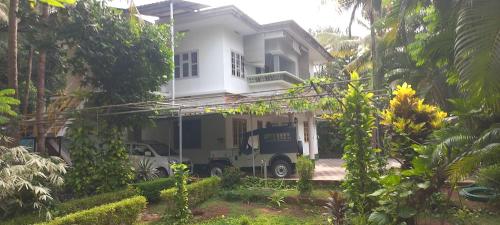 a truck parked in front of a white house at greenview homestay Mayyil in Parassinikadavu