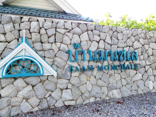 a stone wall with a sign for azonazonazonazonazona barn museum at บ้านมนชเลชะอำ ติดชายหาด Baan Monchale in Ban Sa