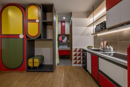 a kitchen with red and yellow doors and a sink at Q Apartment Da Nang in Da Nang