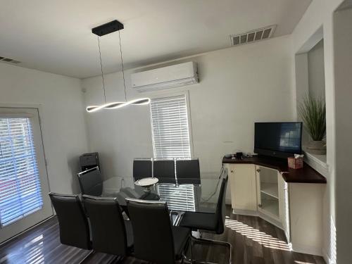 a dining room with a table and chairs and a television at Enjoy Privacy - Pine Mountain - Spacious Home in Pine Mountain Club