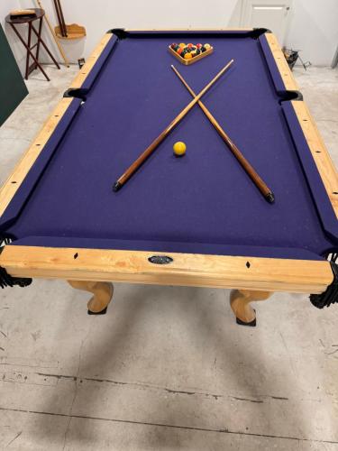 a pool table with cuesticks on top of it at Enjoy Privacy - Pine Mountain - Spacious Home in Pine Mountain Club