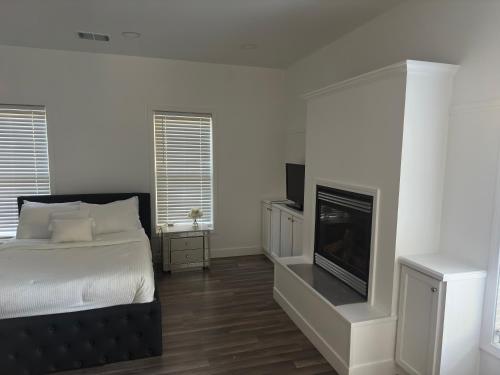 a white bedroom with a bed and a fireplace at Enjoy Privacy - Pine Mountain - Spacious Home in Pine Mountain Club