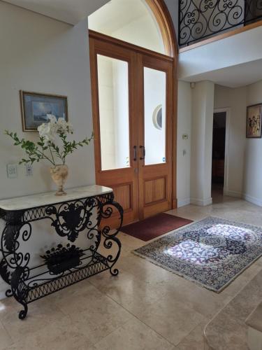 aoyer with a door and a table with a vase on it at GRAND APARTMENT by the Harbor in Sydney