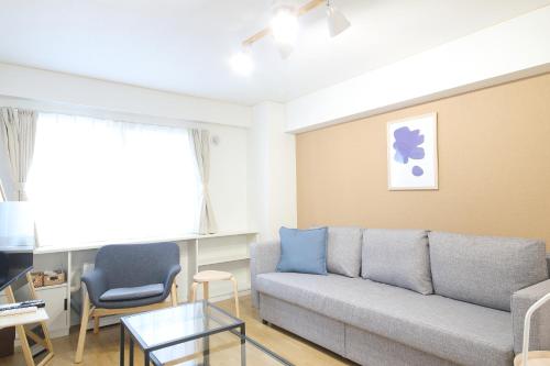 a living room with a couch and a table at ノーザンヒルズ南6条 in Sapporo
