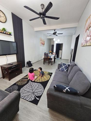 two children are playing in a living room at Hazmi Family Homestay, Islamic Home in Melaka in Ayer Keroh