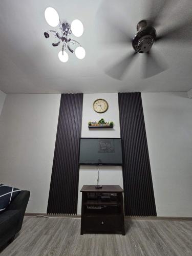 a living room with a ceiling fan and a table at Hazmi Family Homestay, Islamic Home in Melaka in Ayer Keroh