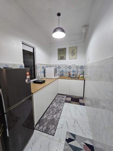 a kitchen with a counter and a refrigerator at Hazmi Family Homestay, Islamic Home in Melaka in Ayer Keroh