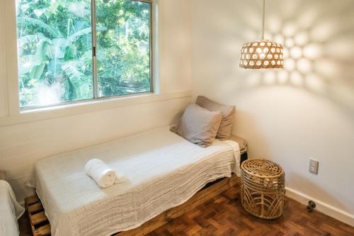 a small room with a bed with a window at RAINFOREST Nest Self-Service Home in Subic Bay - Monkeys, Bats, Roofdeck! in Subic Bay Intl