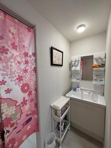 a bathroom with a sink and a mirror at Sakura桜ノ宮ヴィラ in Osaka