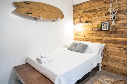 a bed in a room with a wooden wall at RAINFOREST Nest Self-Service Home in Subic Bay - Monkeys, Bats, Roofdeck! in Subic Bay Intl