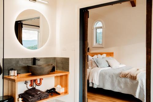 una camera da letto con un letto e uno specchio di The Chapel a Wattle Grove
